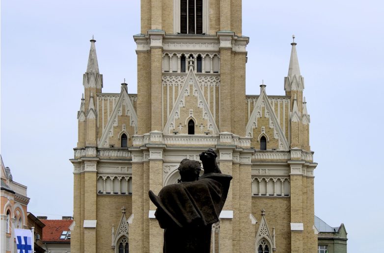 Crkva Svetog imena Marijinog (1893–1896), sa spomenikom Svetozaru Miletiću (1939); Arh. Đerđ Molnar i vaj. Ivan Meštrović; Foto: dr Goran V. Anđelković, u. d. i. a.